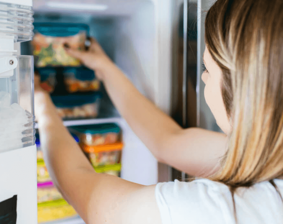 Woman reaching into freezer