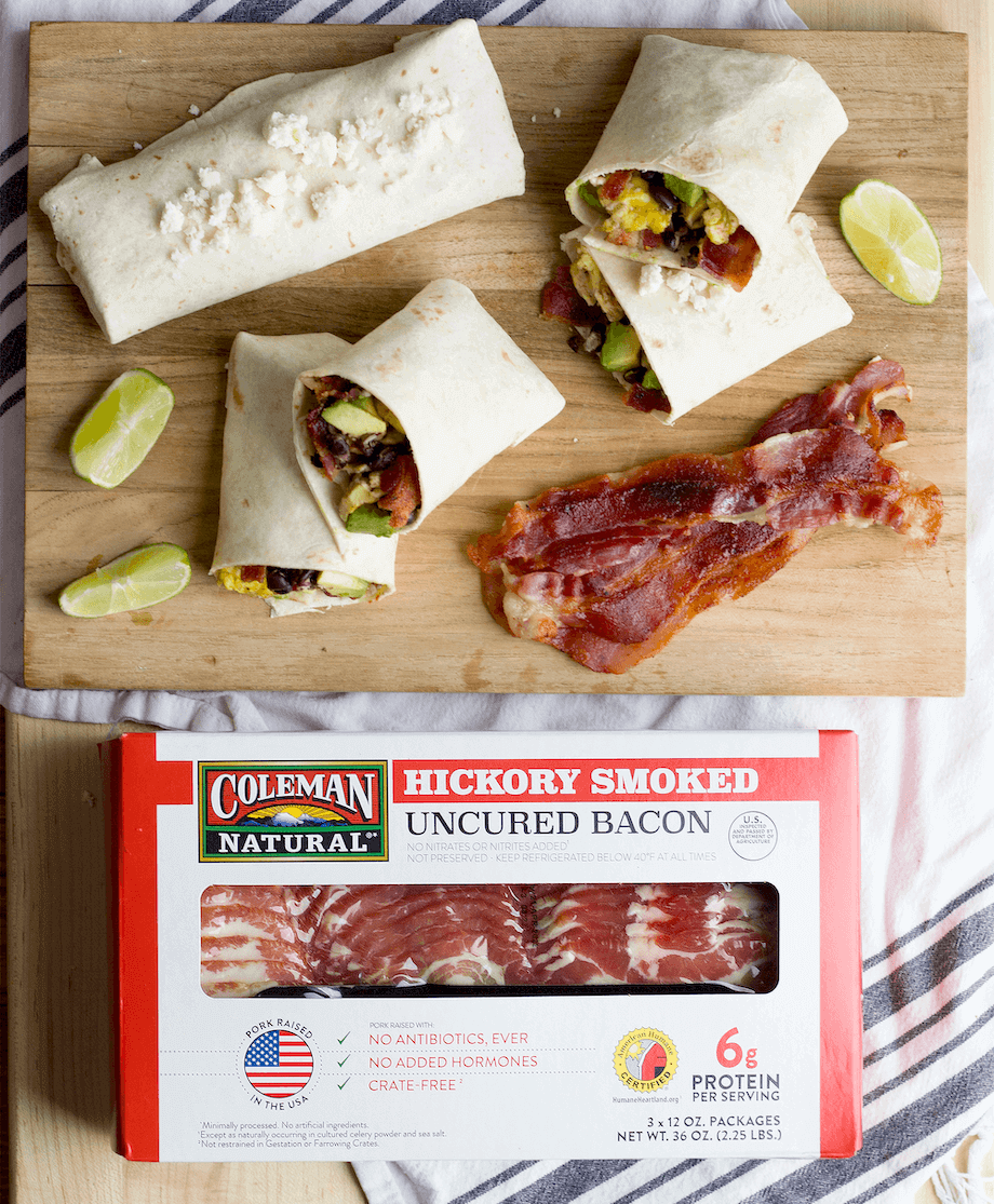 https://www.colemannatural.com/wp-content/uploads/2022/02/Box-of-hickory-smoked-bacon-next-to-tortilla-wraps-with-bacon-and-vegetables-920.png