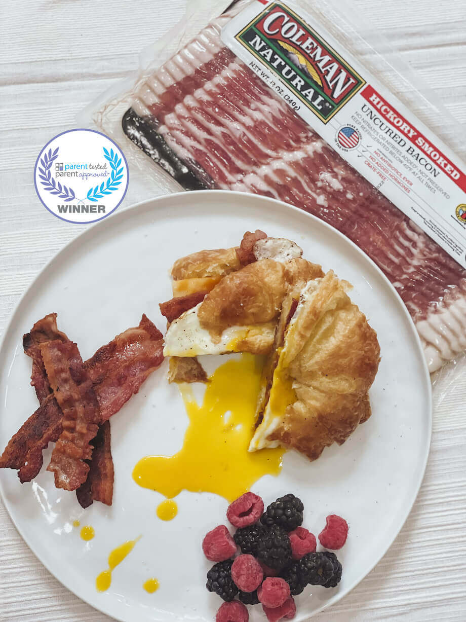 https://www.colemannatural.com/wp-content/uploads/2022/02/Hickory-smoked-bacon-next-to-a-plate-with-a-breakfast-croissant-and-berries-920.jpg