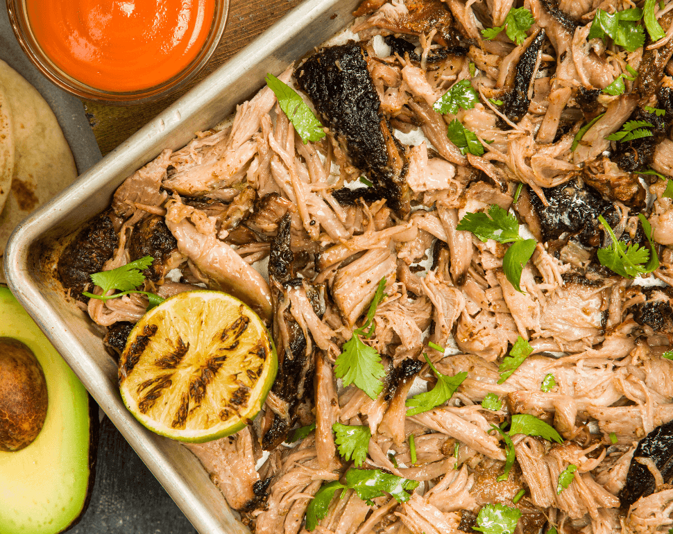Pulled pork in a pan with lime and seasoning